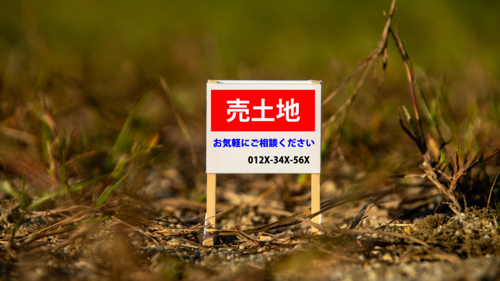 荒地に置かれた売土地の看板のイメージ