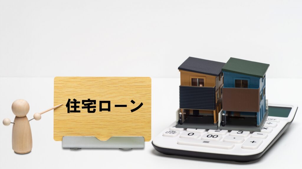 電卓に乗った住宅模型と住宅ローンの文字
