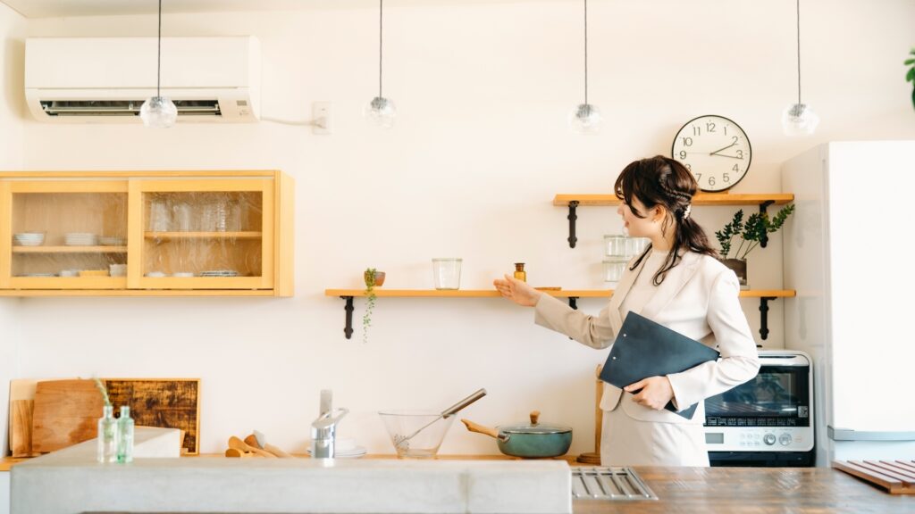 キッチンの設備を説明する女性(棚)