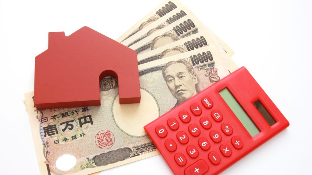 家の模型、電卓、お金